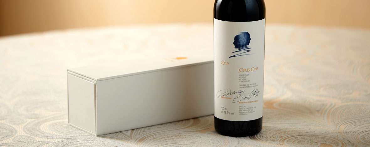 A bottle of Opus One 2019 next to a white gift box