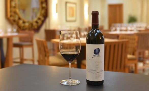 A bottle of Opus One next to a glass of Oakville, California red wine in the Opus One Salon Courtyard